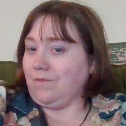 selfie of a nonbinary person slightly smiling